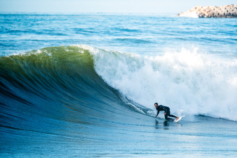 Surfer carving on a powerful wave using a MAR Surfboards performance surfboard
